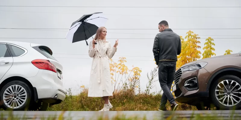 Couple in love on the road near cars under cloudy sky seguro-de-coche-tipo2