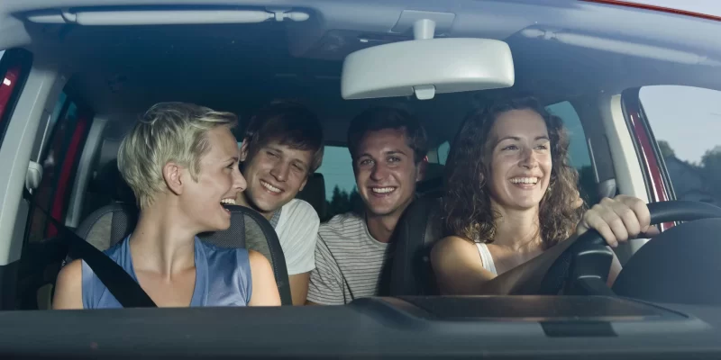 Germany, Bavaria, Young people driving car, smiling, portrait seguro-de-coche-tipo4